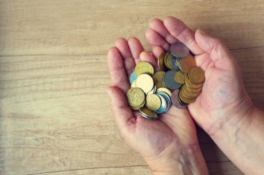 Avuçlarda bozukluklar var. Para elinde. Yoksulluk kavramı, nakit sıkıntısı. Tasarruf. Ukraynaca yazılmış bir madeni para. 50, 25 ve 5 kuruş..