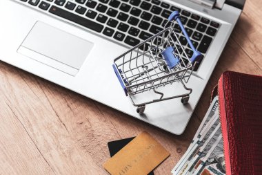 Dizüstü bilgisayarda klavye arkaplanı. Dolarlı kredi kartı ve cüzdan. İnternet üzerinden konsept alışverişi, internet satışları. İnternet 'ten alışveriş.. 