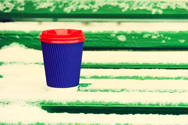 Hot and warming drinks concept. Paper cup with a hot drink on a snowy background.coffee to go  in winter concept. Disposable cup