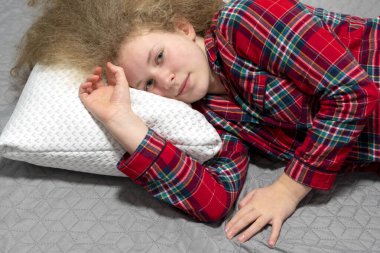 Kız yastığa uzanıyor. Güzel kız uzan, uzan, yatak odasına uzan. İyi bir uyku kavramı. Genç kadın yatakta yatıyor. 