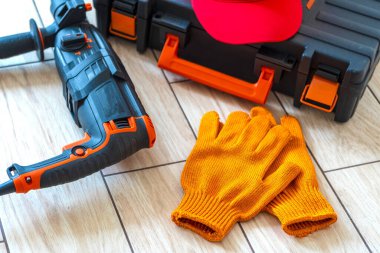 Çalışan aletlerin üst görüntüsü. Döner çekiç, alet çantası, iş kepi, eldivenler. İşçi vitesi konsepti