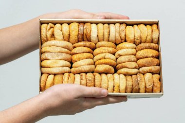  Sıralar dolusu kurutulmuş hurma, kayısı, kızılcık, yabanmersini, elinde kuru erik. Kurumuş meyve arkaplanı.
