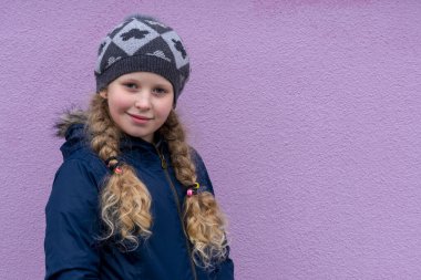 Kız renkli bir arka planda sıcacık giyinmiş. Kalın ceketli bir genç. Kış ve sonbaharda mevsimlik kıyafet kavramı. Boşluğu kopyala