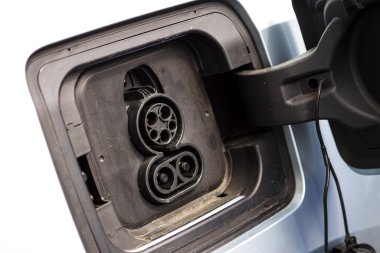  Elektrik şebekesi bir elektrikli arabaya takıldı. Elektrik prizinin görüntüsünü kapatın, şarj oluyor. Çevre dostu alternatif enerji kavramı