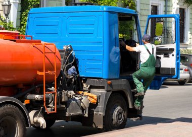 Şoför arabanın yanında. Tankı olan bir araba. Meslek sürücüsü konsepti.