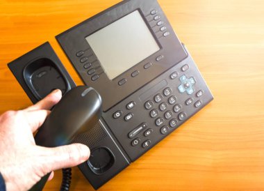 El bir telefon tüpü tutuyor. Yakın plan. Elinle bir numarayı çeviriyorsun. Adamın eli telefondaki düğmeye basıyor. Kanalları ve iletişim türlerini kabul et.