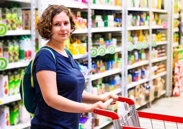 woman with shopping trolley at the grocery store. The girl in shopping mall. The customer holds the basket for products.The housewife buys goods. concept buyer, shopper, shopping
