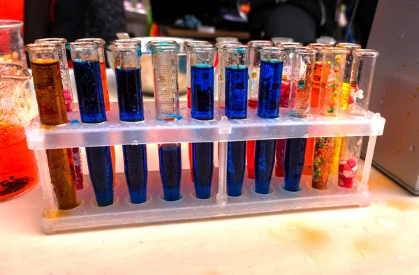装有彩色液体的瓶子 桌上装有不同颜色溶液的实验室玻璃器皿 研究和科学经验的概念结果 科学实验管 — 图库照片