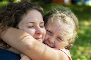 Bir kadına sarılan bir kız. Anne ve çocuğu kucakla. Aile içinde sevgi ve güven kavramı. Anne ve kızı.