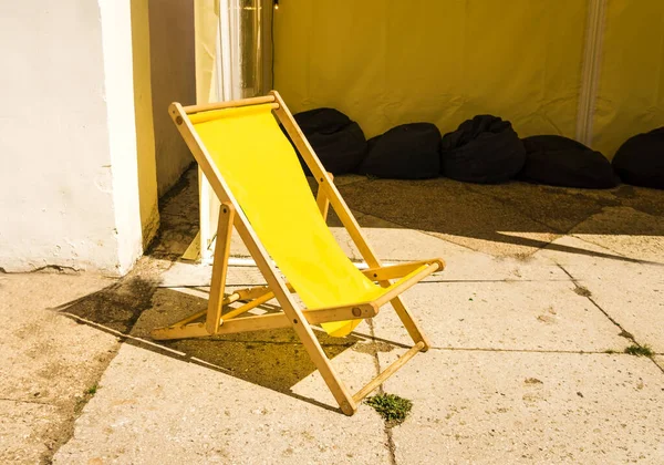 Summer chair.Beach Chaise Lounge Chair. Beach striped chaise-longues standing on sand by the sea. Beach season. Summer seashore.