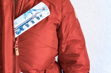 Ceket ve termometre. Kalın giysiler. Kış Ceketi. Daha kalın giyinme konsepti. Soğutma konsepti, soğuk mevsim