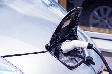  Elektrikli araba şarj oluyor, hortumu şarj ediyor. EV araba geçmişi olan bir ev için elektrikli araç şarj istasyonu. Çevre dostu alternatif enerji kavramı. Elektrikli araba şarj istasyonu elektro hareketlilik çevresi dostu. Boşluğu kopyala