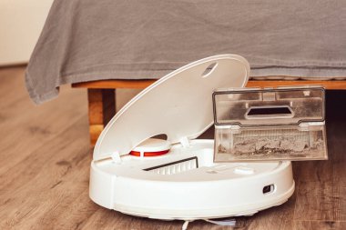  Robot elektrikli süpürge. Çöp konteynırı. Bir kadının eli çöp konteynırını tutuyor.