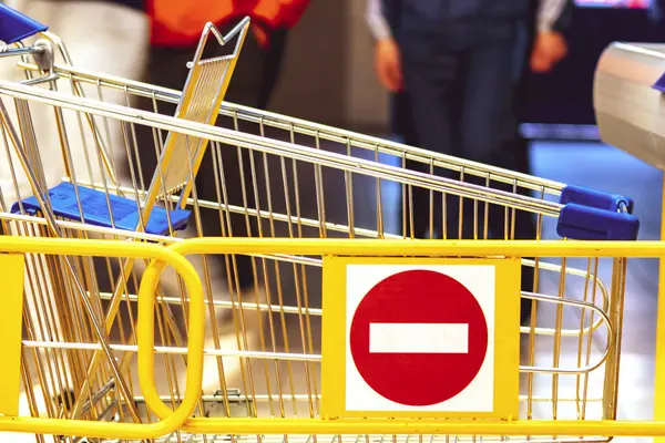 Trolley in the store. stop sign. Concept of ban, end of trade. Closed shops. Store barrier