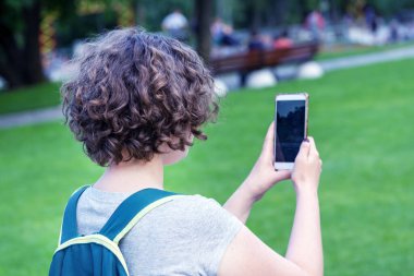 Akıllı telefonlu kız. Ayakta duran ve akıllı telefon kullanan kadın.