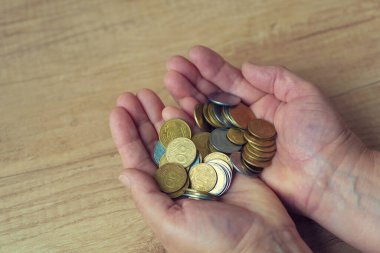 Avuçlarda bozukluklar var. Para elinde. Yoksulluk kavramı, nakit sıkıntısı. Tasarruf. Ukraynaca yazılmış bir madeni para. 50, 25 ve 5 kuruş..