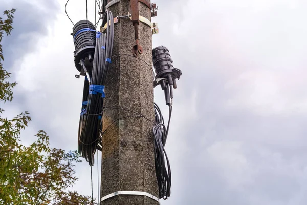 pole with wires. wires cables on Electric poles.A fiber optic cable harness on a concrete column. Telecommunications and Internet. Tangled electric cables