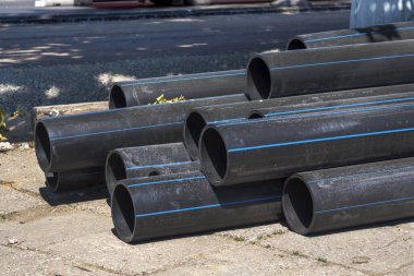 Plastik ana siyah borular. Su tedarik sistemi için bir yığın polietilen borusu. Şehir haberleşmesi ve kanalizasyon için nesneler. Kentsel iletişim kurma kavramı