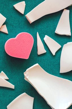 Parçaların arasında bir kalp. Mutsuz aşkın sembolü. Kötü sağlık konsepti. Beyaz parçalar ve kalp. yakın plan