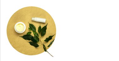  Yaprak yeşili, kozmetik şişe, kahverengi daireli krema izole edilmiş arka plan. Doğal yeşil incir yaprağı, kozmetik şişe, alet, yuvarlak, beyaz arka planda izole edilmiş aralık. Güzellik, organik vücut kozmetikleri, spa konsepti. Çevre dostu kozmetoloji produ