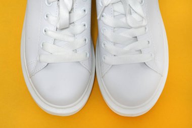 Beyaz spor ayakkabılar, renkli arka plan. Spor ayakkabılar, yaşam tarzı spor ayakkabıları. Şık beyaz ayakkabılar. Üst görünüm. Boşluğu kopyala                               