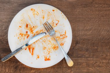 Yemekten sonra kirli tabak. Tabakta çatal ve bıçak. Yemekten sonra kirli tabak. Yemeğin sonu. İyi iştah, lezzetli yemek ve yemek konsepti. en üstteki görünüm