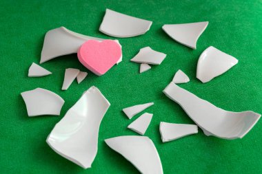 Parçaların arasında bir kalp. Mutsuz aşkın sembolü. Kötü sağlık konsepti. Beyaz parçalar ve kalp. yan görünüm