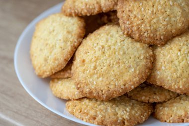 Tabakta susamlı kurabiye. Yığınla susamlı kurabiye. Lezzetli ve tatlı susamlı kurabiyeler. Ev yapımı pişirme konsepti