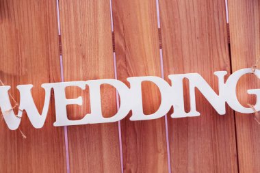 Yeni evliler, düğün, evlilik. Düğün töreninin yapılacağı yeri gösteriyor. Sadece evlilik imzası. Tahta arka planda yeni evlenmiş.