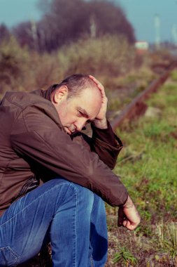 Düşünceli adam raylara oturur. Stresli olan kişi. Stres kavramı, yaşam yetersizliği, sorun. Üzgün erkek.