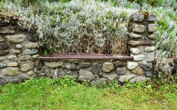 The bench built into the wall made of cobblestones.Decorative bench. Beautiful landscape