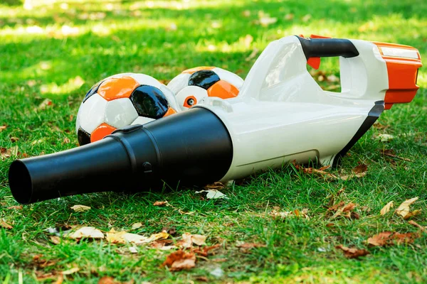 Leaf blower on the ground. The device for cleaning of fallen leaves in the fall. Leaf fall. Garden vacuum cleaner on a lawn with yellow leaves.