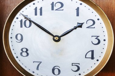 Ahşap arka planda eski bir antika saat. Duvardaki saatin yuvarlak kadranı. Kavram zamanı akıyor. Zaman kavramı. Saat, saat, zamanlayıcı, saat tutucu, saat tutucu. 