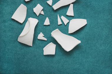 Kırık beyaz kapların kıymıkları ve parçaları. Bir aile kavgasının metaforu. Kırık tabak, cam. Mutfaktaki kaza kavramı. Parçalanmış tabak parçaları.. 