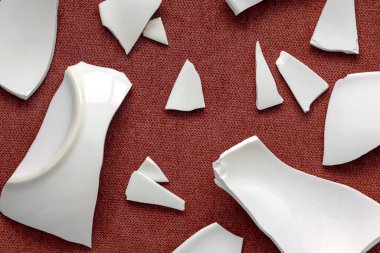 Kırık beyaz kapların kıymıkları ve parçaları. Kırık tabak, cam. Parçalanmış tabak parçaları. Yakın çekim, üst görünüm