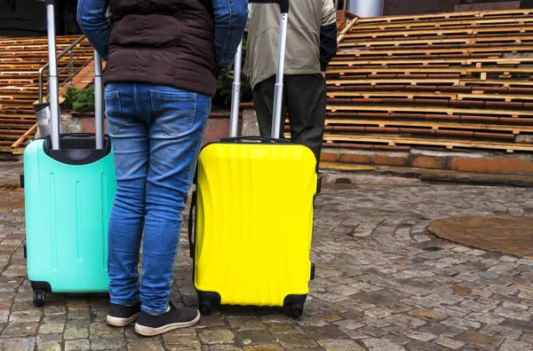 Person with two colored suitcases. Bags for a trip. Colored Bags. Concept moving, travel, trip, flight. Concept Summer rest, holidays.  suitcase for travel.