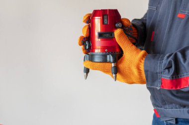 İşçi ve Baloncuk, lazer seviyesi. Kırmızı lazer seviyesiyle ölçülüyor. Ölçüm doğruluğu kavramı, modern ölçüm aletleri