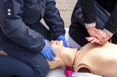 Diriltme egzersizi sırasında manken üzerindeki bir polis memurunun elleri. Kalp masajı ilk yardım eğitim konsepti. Acil bakım..