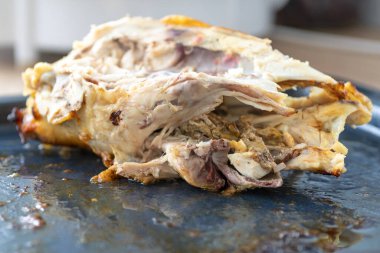 Pişirme tepsisinde yemek artıkları. Kemirilmiş tavuk leşi. Lezzetli yemek. Yemekten sonra. Çatal bıçak, bıçak. Yağlı, sağlıksız gıda konsepti, iyi iştah.