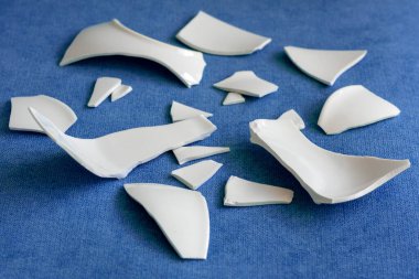 Kırık beyaz kapların kıymıkları ve parçaları. Kırık tabak, cam. Parçalanmış tabak parçaları. Yakın plan, kenar görünüm