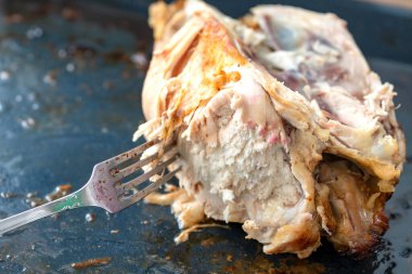 Pişirme tepsisinde yemek artıkları. Kemirilmiş tavuk leşi. Lezzetli yemek. Yemekten sonra. Çatal bıçak, bıçak. Yağlı, sağlıksız gıda konsepti, iyi iştah.