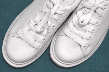 Beyaz spor ayakkabılar, renkli arka plan. Spor ayakkabılar, yaşam tarzı spor ayakkabıları. Şık beyaz ayakkabılar. yakın plan