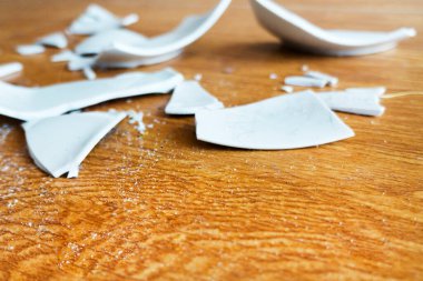 Kırık beyaz kapların kıymıkları ve parçaları. Kırık tabak, cam. Parçalanmış tabak parçaları. Yakın plan, kenar görünüm