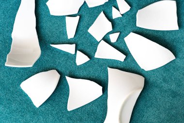 Kırık beyaz kapların kıymıkları ve parçaları. Bir aile kavgasının metaforu. Kırık tabak, cam. Mutfaktaki kaza kavramı. Parçalanmış tabak parçaları.. 