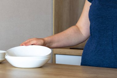  Kadın tabakları masaya koyar. Bulaşık, bulaşık, mutfak, bulaşık makinesi. tabak, 