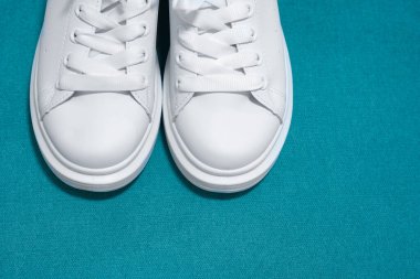 Beyaz spor ayakkabılar, renkli arka plan. Spor ayakkabılar, yaşam tarzı spor ayakkabıları. Şık beyaz ayakkabılar. Üst görünüm. Boşluğu kopyala