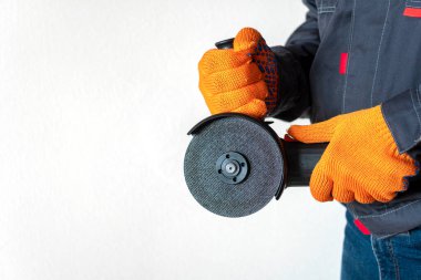 İşçi bir disk ile öğütme makinesi tutuyor. Boşluğu kopyala