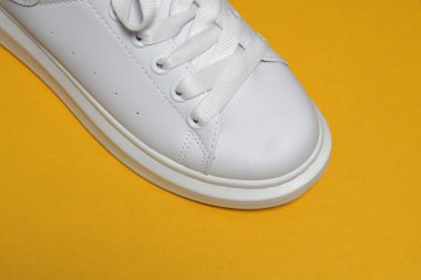 Beyaz spor ayakkabılar, renkli arka plan. Spor ayakkabılar, yaşam tarzı spor ayakkabıları. Şık beyaz ayakkabılar. Üst görünüm. Boşluğu kopyala                               