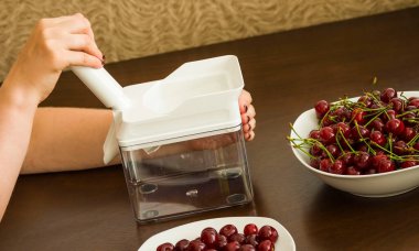 Kirazdan bir taşın çıkarılması. Bir taşın çıkarılması ve kirazın işlenmesinde kullanılan plastik bir alet. Kiraz kasesi