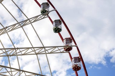 Çocuklar ve yetişkinler için lunapark eğlenceleri. Güzel mavi bir gökyüzünün arka planında dönme dolap..